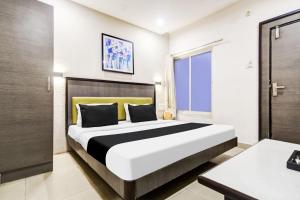 a bedroom with a large bed in a room at Super Townhouse Dewas City Formerly Utsav in Dewās +34 photos
