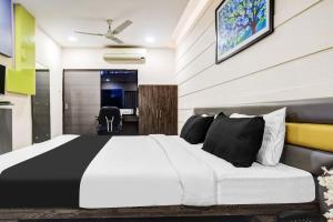 a bedroom with a black and white bed and a desk at Super Townhouse Dewas City Formerly Utsav in Dewās