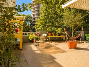 a patio with tables and chairs and potted plants at Youki Haus Hostel in Montevideo