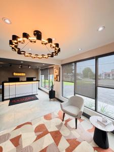 a living room with a chandelier and a chair at Ramada by Wyndham Kingston in Kingston