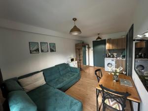 a living room with a blue couch and a table at Bakuriani Panorama in Bakuriani +13 photos