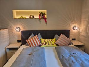 a bedroom with a large bed with colorful pillows at LINDENGUT - Boutique Hotel nahe IKUNA Park in Natternbach