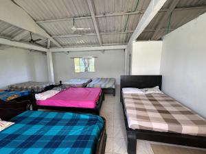 a room with three beds in it at Casa Finca pasadia cerete in Cereté +23 photos