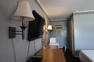 a room with a bed and a table and a lamp at Starlite Motel in Heath