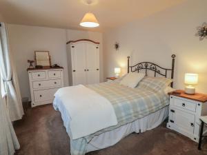 a bedroom with a bed and two dressers and a mirror at Shaws Hill Farmhouse in Ballymena
