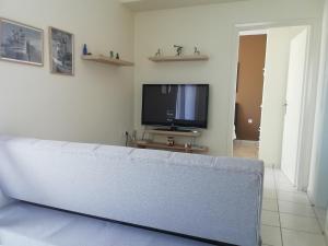 a living room with a couch and a flat screen tv at La petite maison in Xiropigado