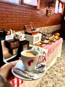 a person holding a cup of coffee on a table at Pensiunea Daniel in Sibiu