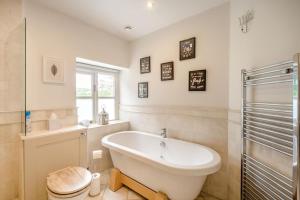 a white bathroom with a tub and a shower at 7 Bed in Langbar oc-d34075 in Middleton +49 photos