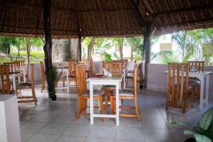 a group of tables and chairs in a restaurant at Musituni Luxury Villas in Diani Beach