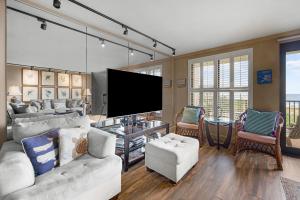 a living room with a white couch and a flat screen tv at Litchfield Beach & Golf Resort in Pawleys Island +29 photos
