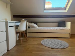 a bedroom with a bed and a desk and a chair at Rose CosyHome Paris Champs in Champs-sur-Marne