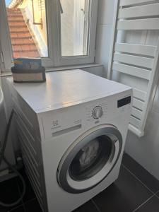 a white washing machine in a room with a window at Rose CosyHome Paris Champs in Champs-sur-Marne