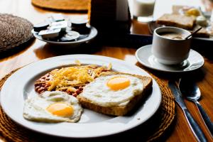 a plate of breakfast food with eggs on a table at Hotel Satwah Luxe Stay - 1 Minute From Nizamuddin Railway Station And India Gate in New Delhi