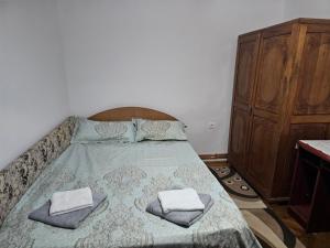 a bedroom with a bed with two towels on it at Casa Narcisa in Călimăneşti