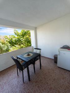 a table and chairs in a room with a window at Apartments Šešo B in Pag