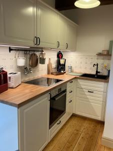 a kitchen with white cabinets and a sink at Reetglück in Haseldorf +9 photos