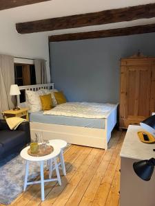 a bedroom with a bed and a table and a couch at Reetglück in Haseldorf