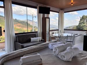 a living room with a couch and a large window at Sítio Volta Fria in Pedra Menina