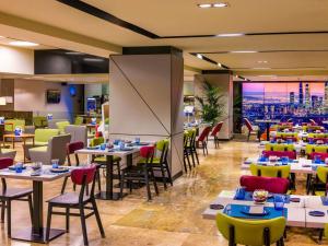 a restaurant with tables and chairs with a view at Novotel Madrid Center in Madrid