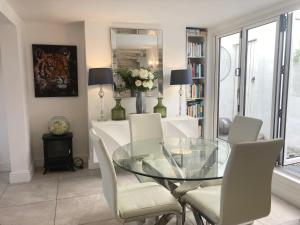 a dining room with a glass table and chairs at Sommersway Cottage in Torquay +45 photos