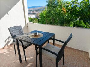 a table and two chairs on a patio with a view at Apartments Šešo B in Pag