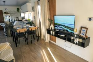 a living room with a flat screen tv on a wall at Departamento de Lujo a 8 min del centro in San Nicolás de los Arroyos