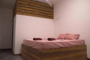 a bedroom with a bed with a wooden headboard at Arugambay Wave House in Arugam Bay