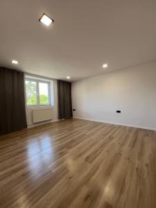 an empty room with a wooden floor and a window at Jastrabie House in Trenčianske Jastrabie