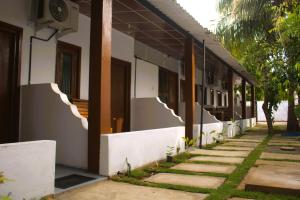 a side of a building with a sidewalk next to it at Arugambay Wave House in Arugam Bay