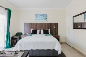 a bedroom with a large white bed and a table at Edenvale corner in Edenvale +41 photos