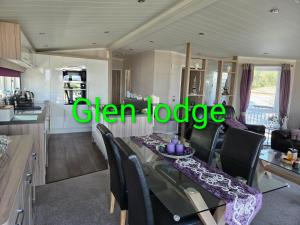 a dining room and kitchen with a green sign that reads clear lodge at Glen lodge Craig Tara in Ayr