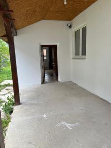 an empty patio of a white house with a door at Jastrabie House in Trenčianske Jastrabie