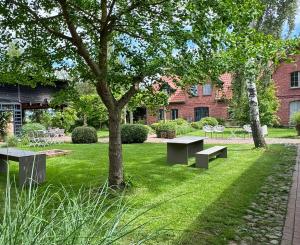 a park with benches and a tree and a building at Ferienwohnung FÜNF Hof Himmelgrün in Saal