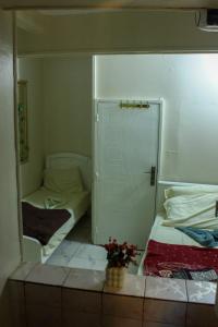 a small room with two beds and a mirror at El Temsah Hotel in Cairo