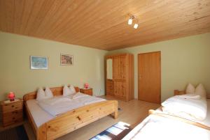 Un dormitorio con dos camas y techo de madera. en Villa Familia, en Bartholomäberg