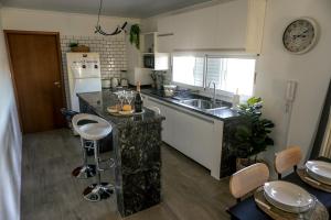 a kitchen with a counter and a sink and a counter top at Departamento de Lujo a 8 min del centro in San Nicolás de los Arroyos +30 photos