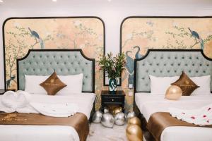 two beds in a hotel room with gold decorations at Crown Luxury Hotel in Hanoi