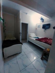 a room with two beds and a tv in it at El Temsah Hotel in Cairo