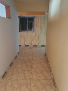 an empty room with a window and a tile floor at Residence Hotel Kolia in Yamoussoukro