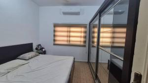 a small bedroom with a bed and a window at نورس هوم in Al Ghuşnah