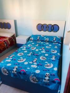 a bedroom with a bed with panda characters on it at نورس هوم in Al Ghuşnah