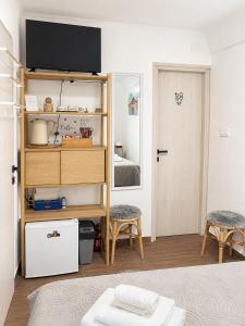 a bedroom with a bed and a television on a shelf at Room Jakov in Šibenik