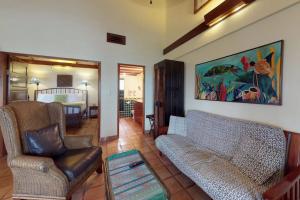 a living room with a couch and chairs and a bedroom at Condo #31 @ Beachside Villas in Placencia