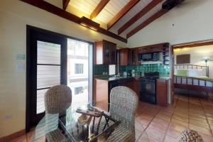 a kitchen with a glass table and chairs at Condo #31 @ Beachside Villas in Placencia +19 photos