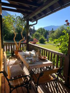 a wooden deck with a table and chairs on it at Privatzimmer in Steinfeld