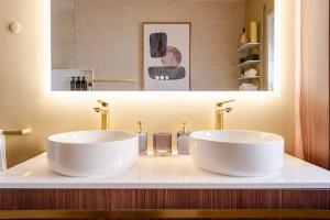 two white sinks sitting on a counter in a bathroom at The Quinta & Studios in Quinta do Conde