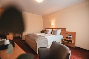 a hotel room with a bed and a chair at Filet & Freunde in Oelsnitz