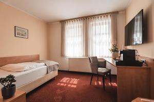 a bedroom with a bed and a desk and a chair at Filet & Freunde in Oelsnitz