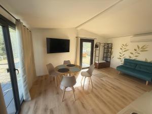 a living room with a table and chairs and a couch at Amici del Colle - Olive Tiny Houses in Borgo a Buggiano +1 photo