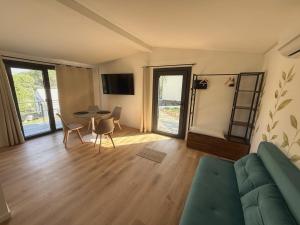 a living room with a couch and a table and chairs at Amici del Colle - Olive Tiny Houses in Borgo a Buggiano